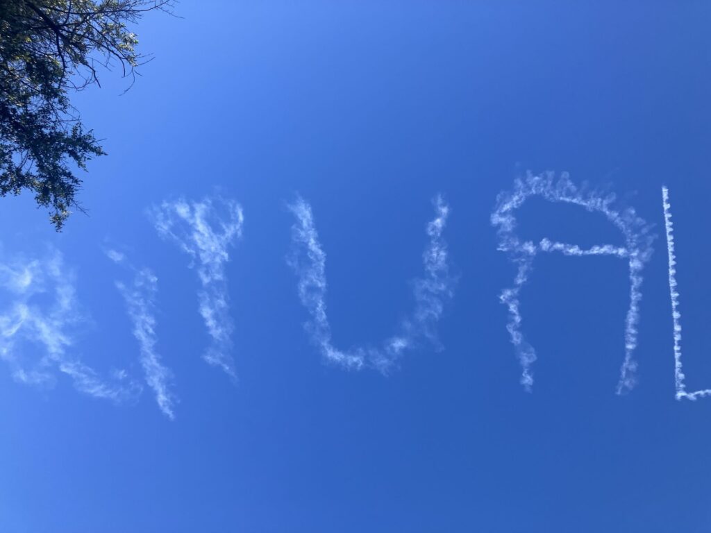 Writing in the sky, appearing as white clouds. The word is “RITUAL.”